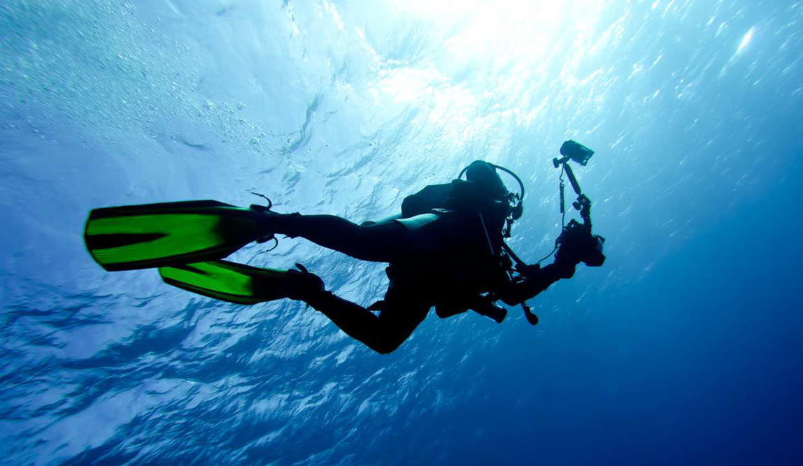 Diver in mid water taking photos